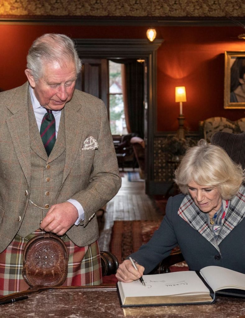 Duke and Duchess of Rothesay signing the hotel guest book.